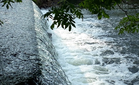 Wasser fließend am einem Wehr